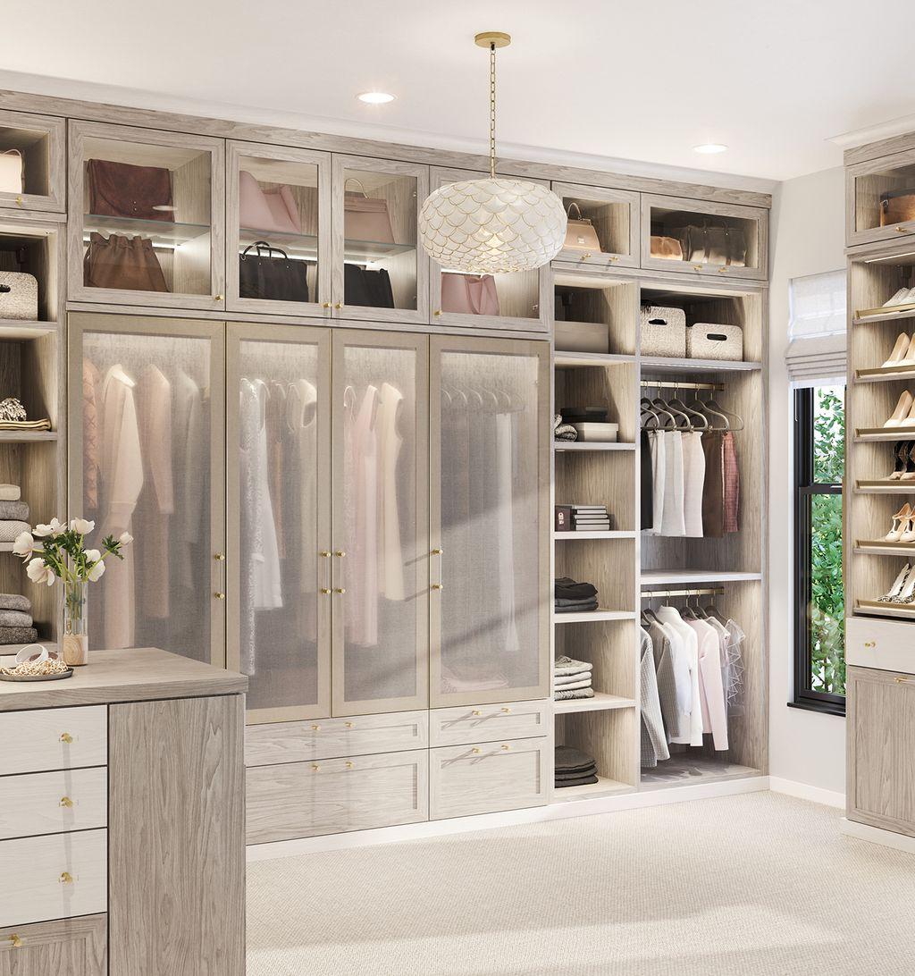 Walk-in closet featuring light grain finish, see-through wardrobe doors, and built-in shelving by California Closets