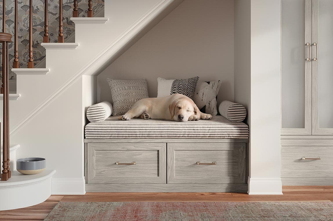 Entryway custom built storage bench and pet space understairs area designed by California Closets