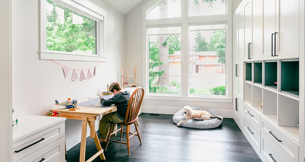 Budding artist in his craft studio design with custom cabinets and shelving from California Closets