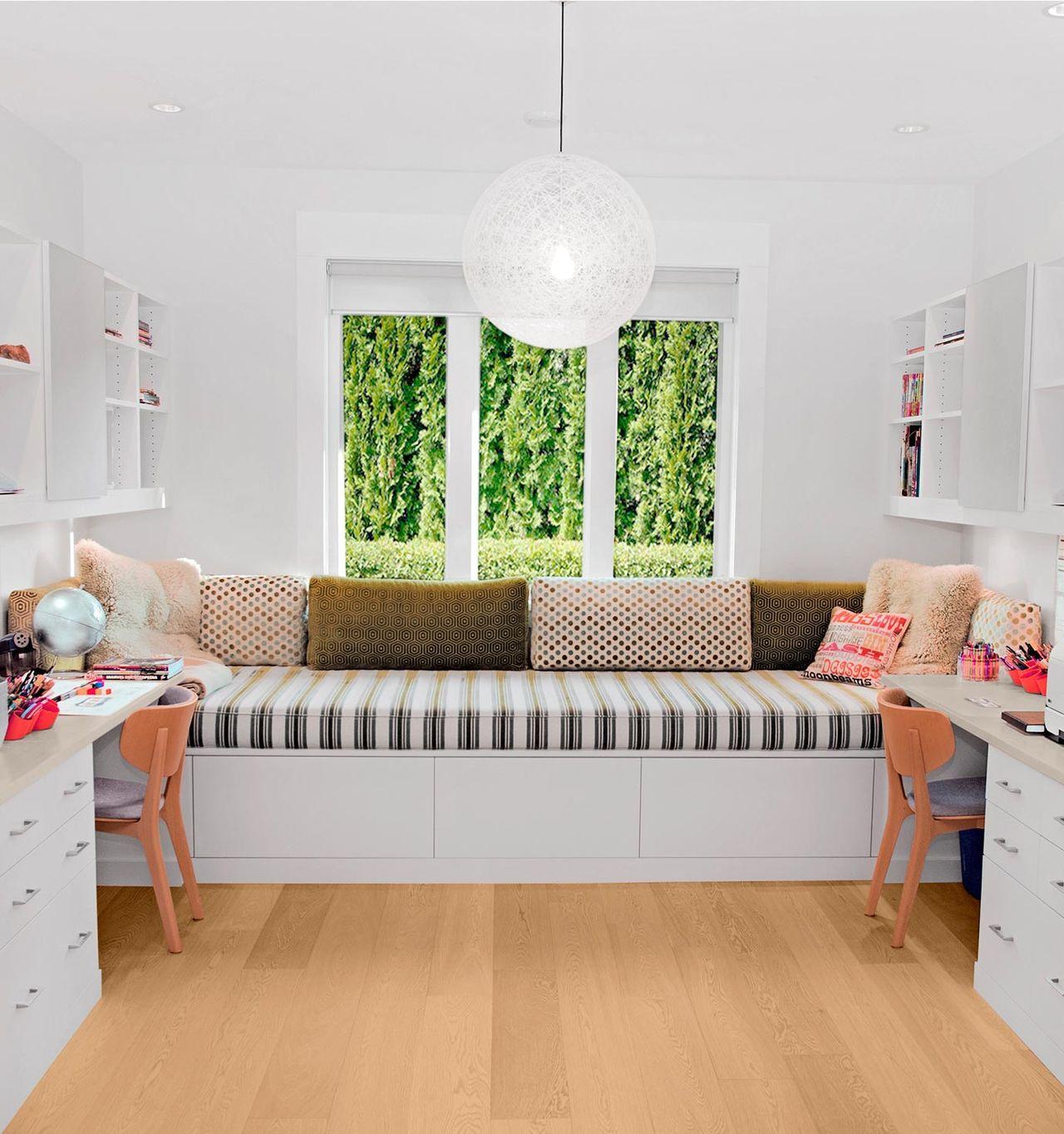 Room with built-in desks on both sides of a large window seat, featuring shelves and storage by California Closets.