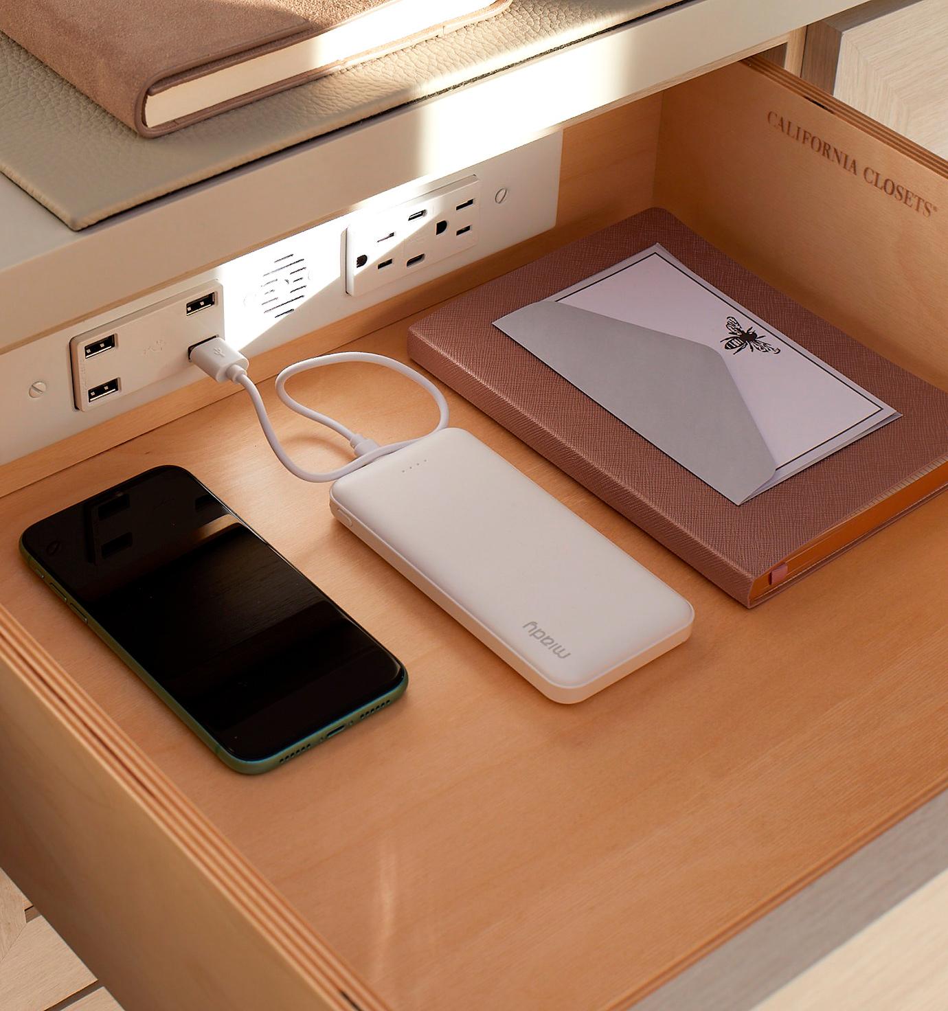 Charging station inside a custom built desk drawer by California Closets