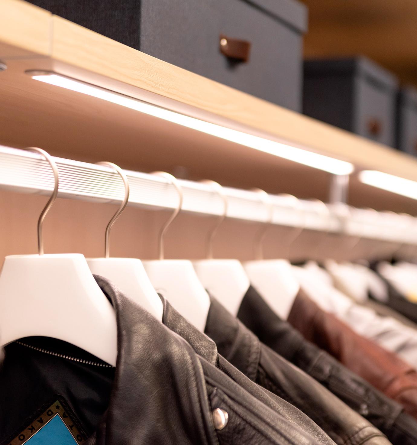 Custom wardrobe closet accessories LED lighting over clothing rods by California Closets