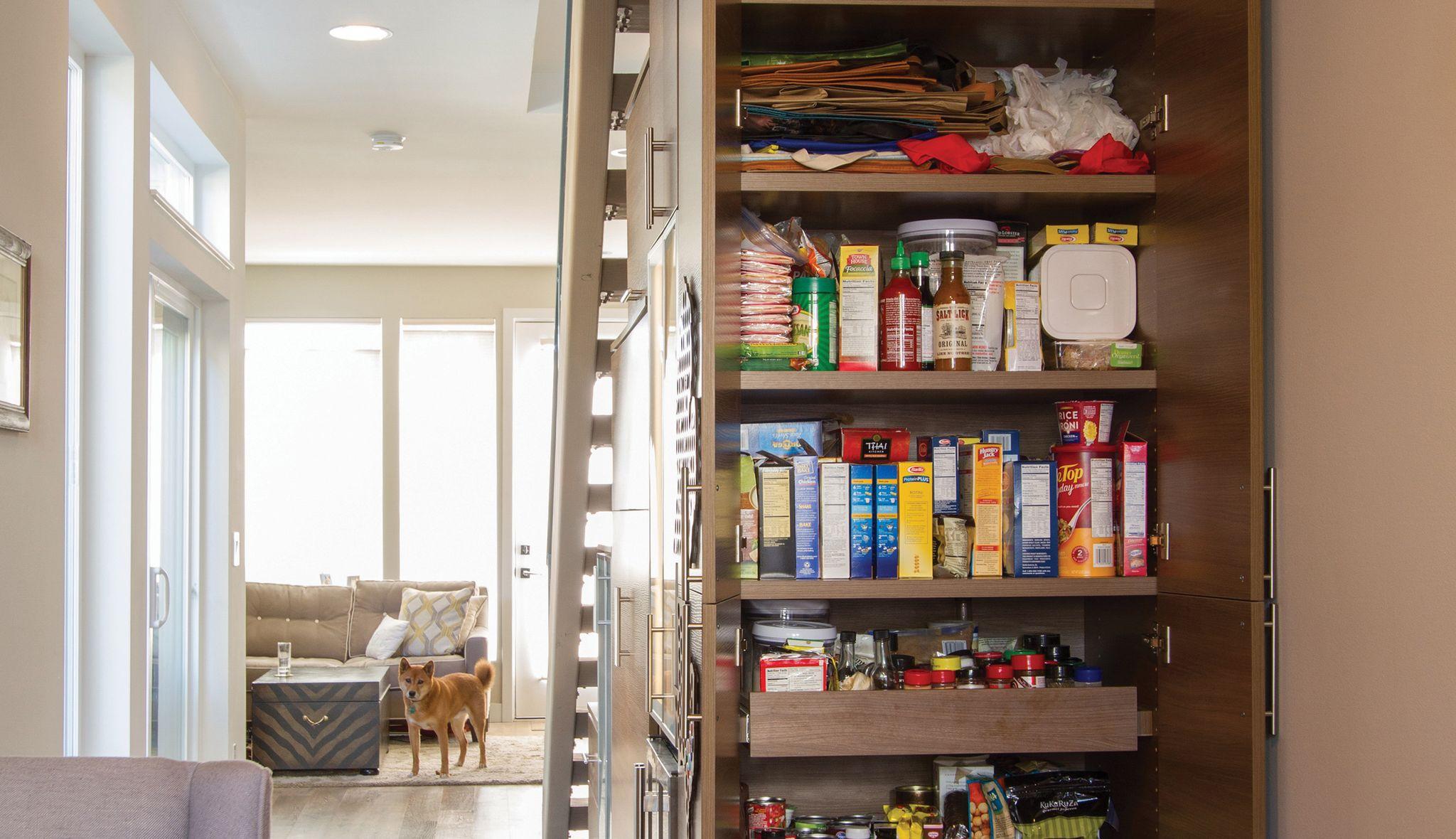 Understairs kitchen pantry with shelving and pull-out drawers by California Closets