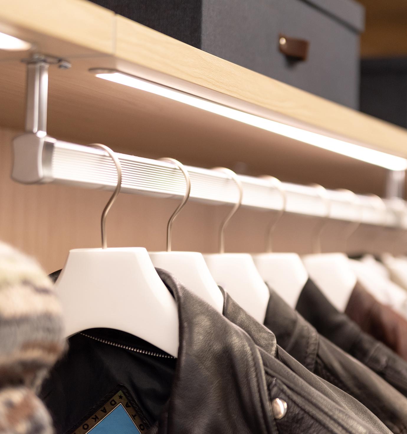 Custom built LED lighting for walk in closet with open shelving by California Closets