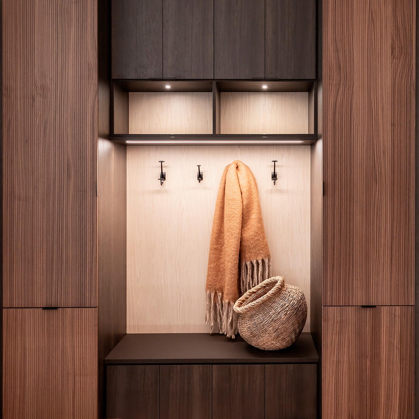 Custom storage bench for entryway made in a dark wood finish by California Closets