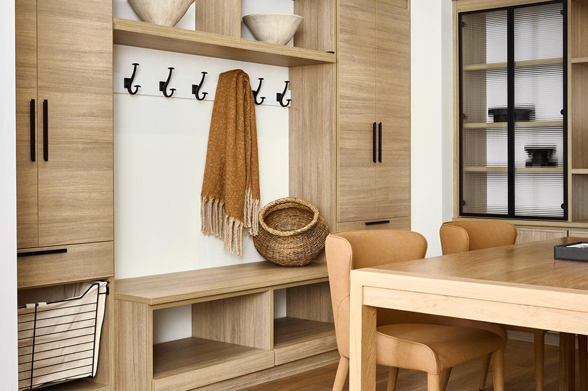 Custom pantry storage design in mudroom with pull out baskets by California Closets