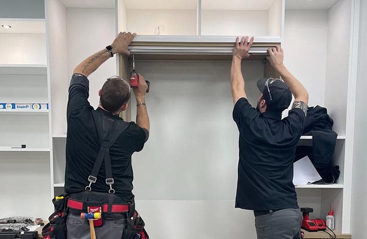 Custom cabinets being added to home storage solution by California Closets installers