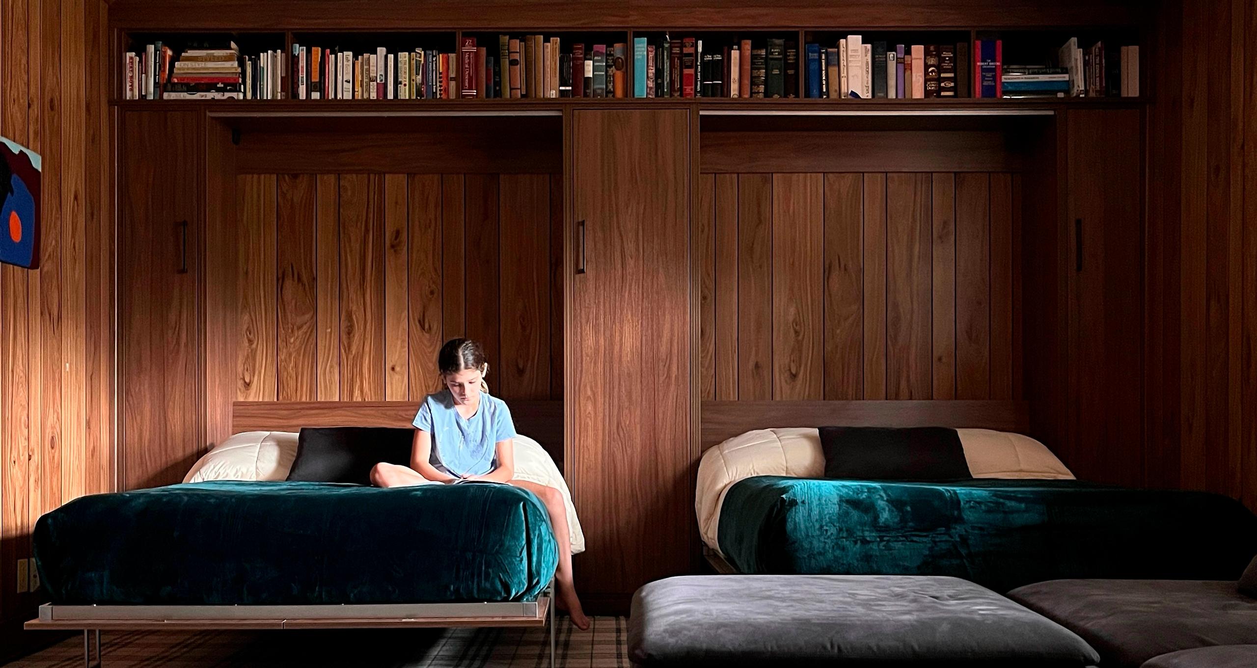 Opened double Murphy beds shown with book storage shelving in a dark wood finish from California Closets