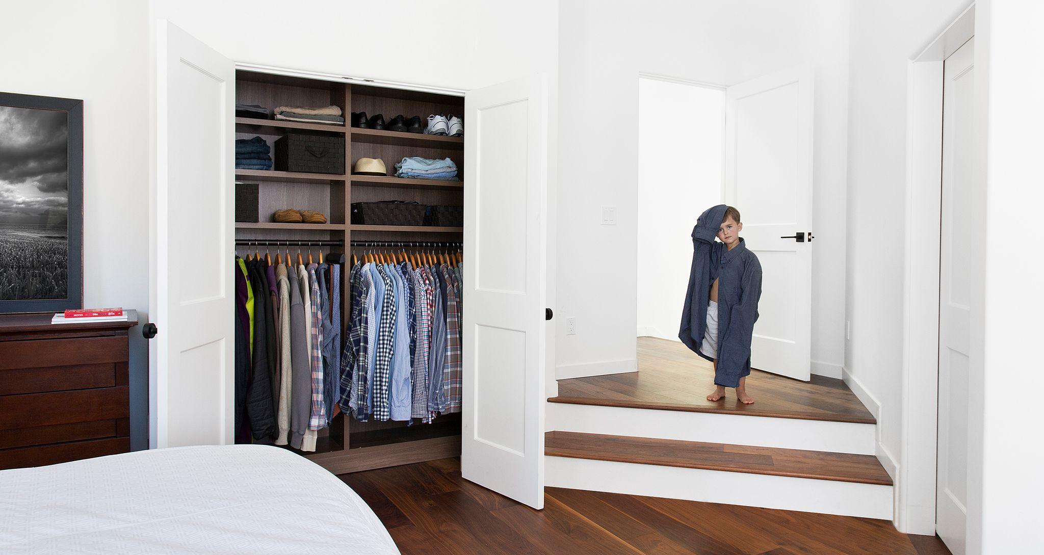 Closet reachin storage design with custom shelving in dark wood finish by California Closets