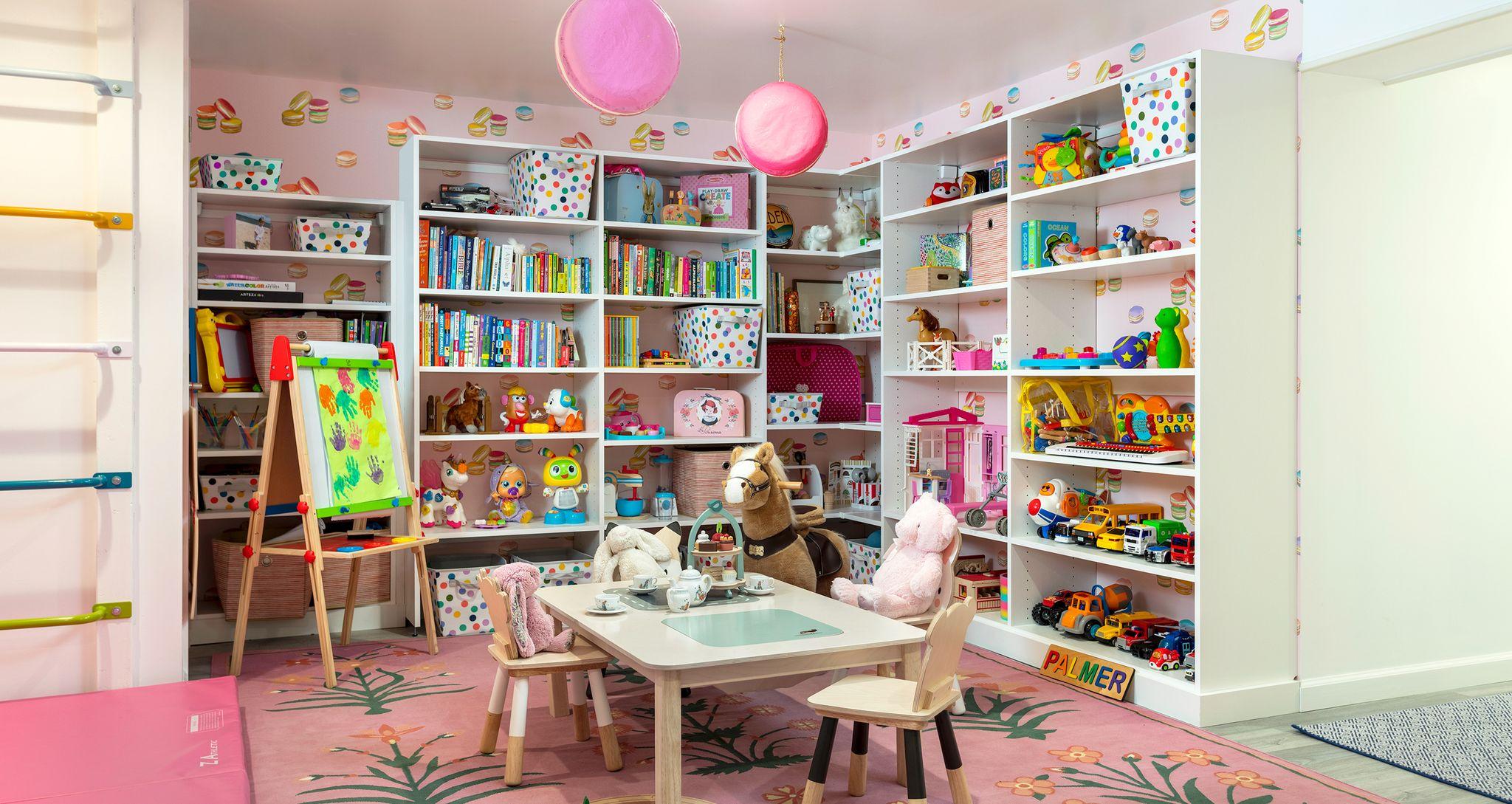 Customized storage for a kid's playroom with bookshelves rock wall by California Closets