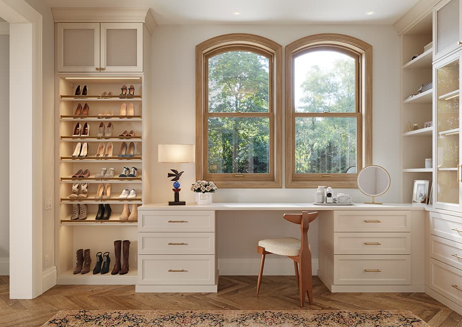 Closet shoe storage shelving with toe rails next to custom vanity desk by California Closets.