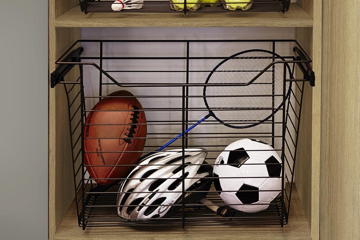 Customized garage storage with pull out wire baskets for sport gear by California Closets
